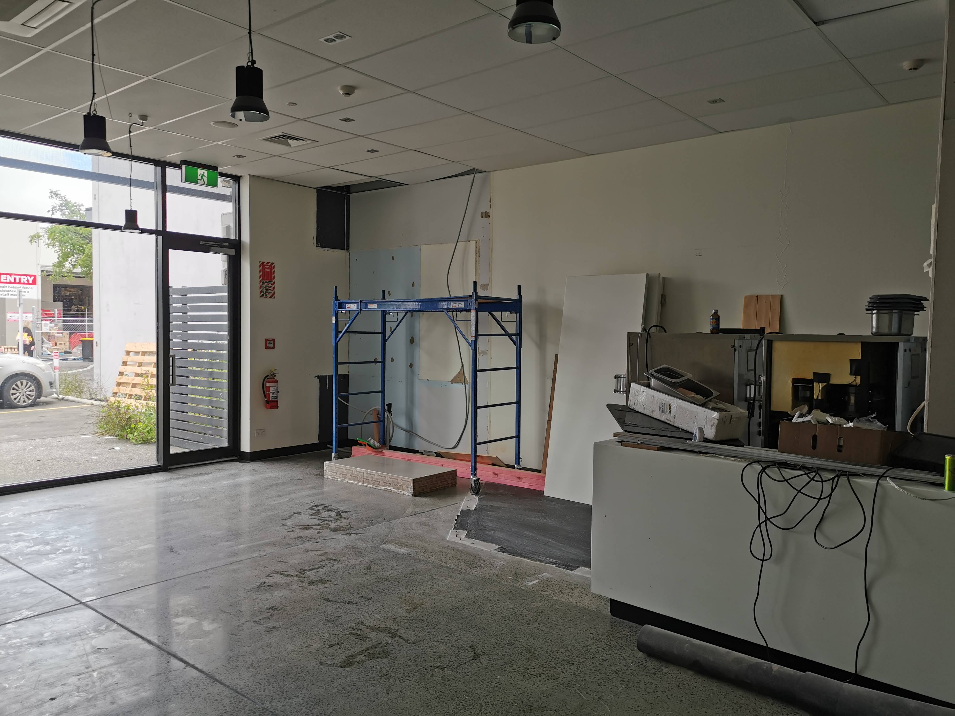 An empty commercial retail space with scaffolding, the kind of site photo needed to start a mural quote