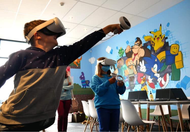 Pixel Party — a customer playing a VR game in the room, mural in the background
