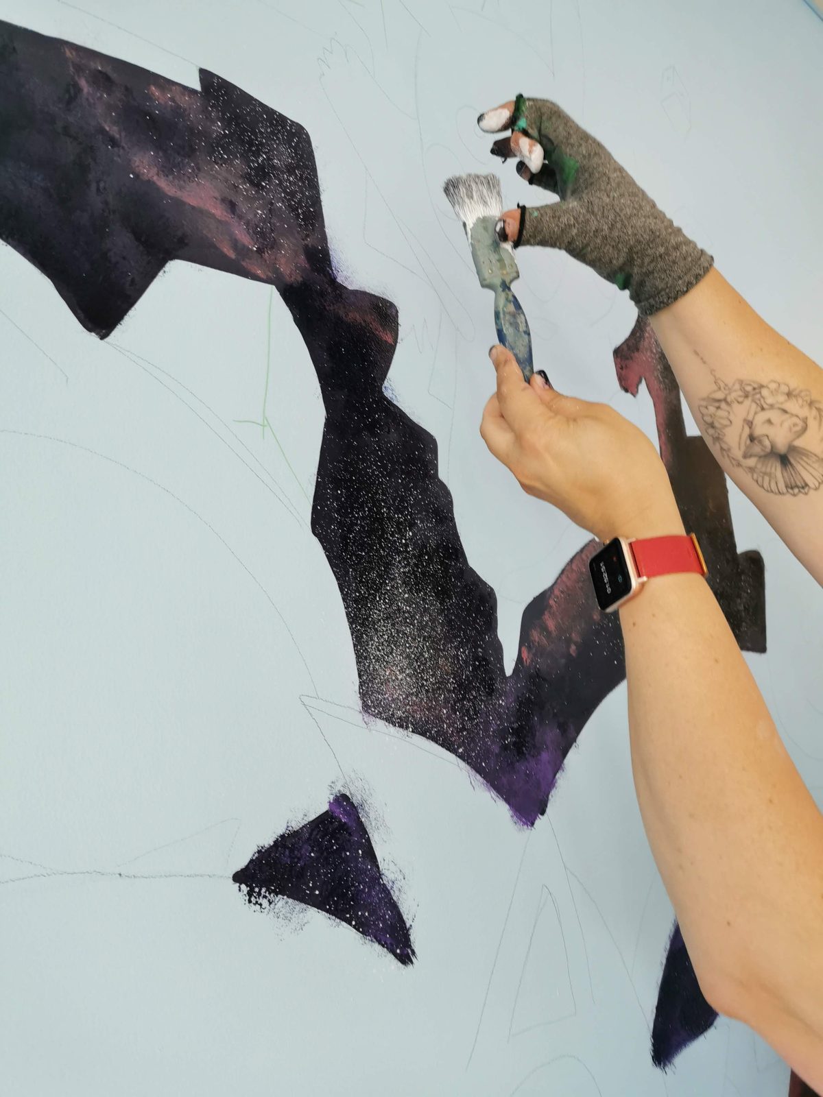 Pixel Party mural in progress — close-up of spray paint being applied to the design
