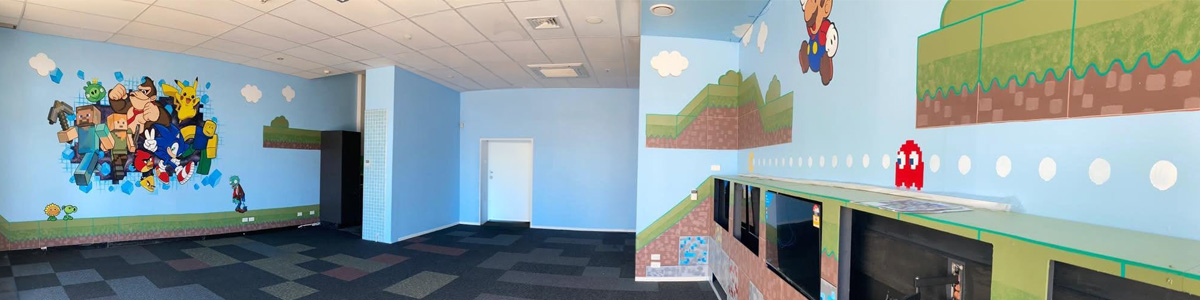 Pixel Party mural — room view with a Minecraft, Donkey Kong, Pikachu and Sonic feature wall on one side and a Super Mario-style landscape with a Pac-Man ghost on the other