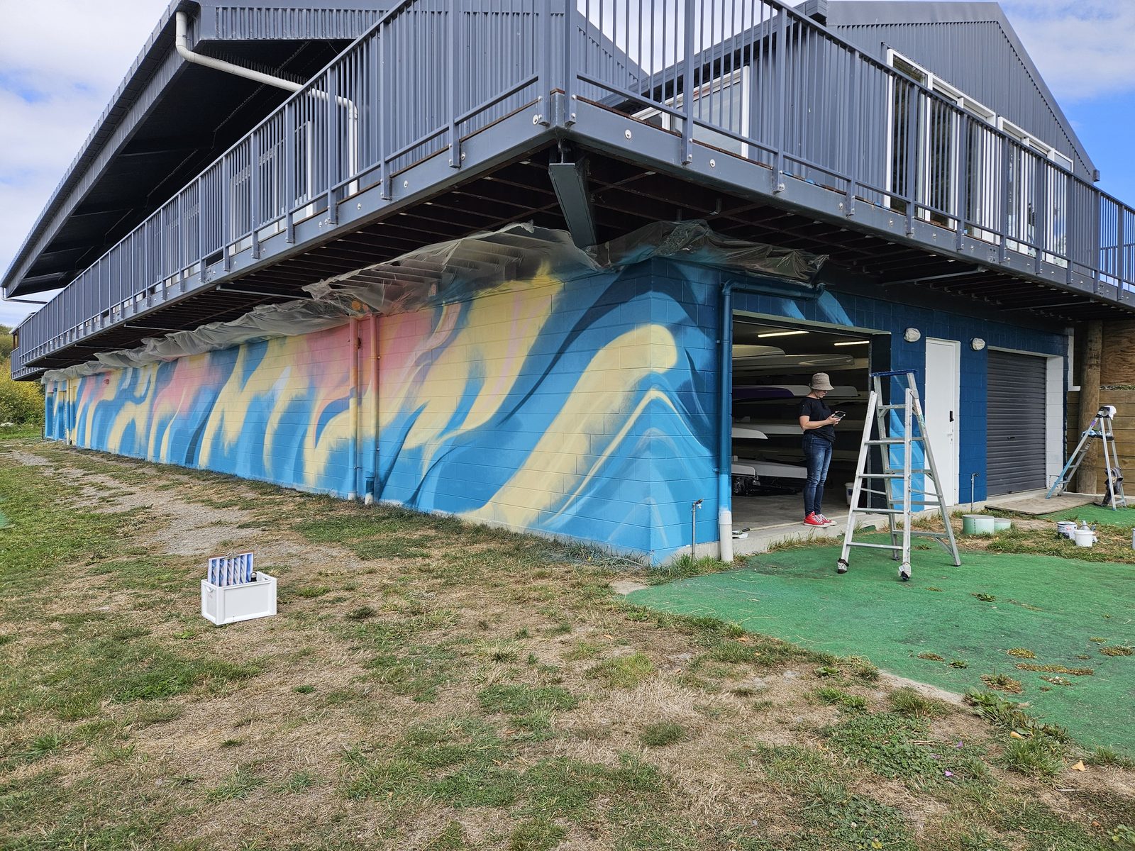 Pulling Together mural in progress — blue and purple base coat with scaffolding against the wall