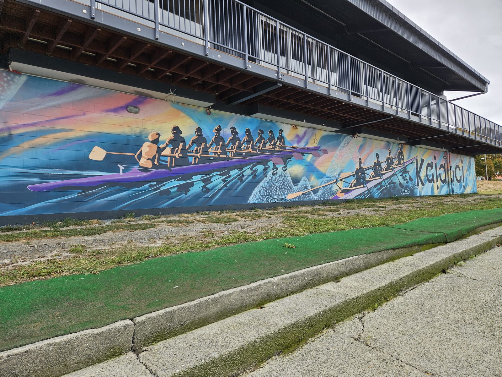 Pulling Together mural — close view of the rowing crew design along the building