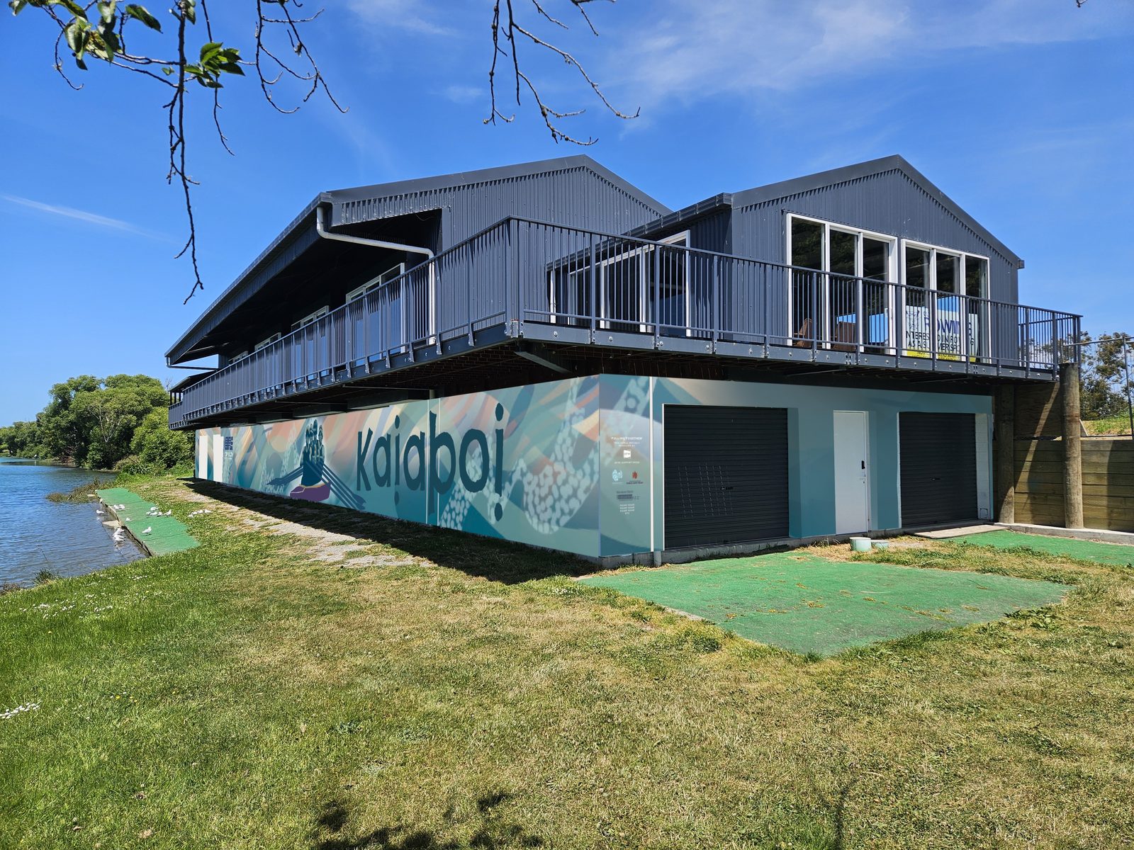 Pulling Together mural — low-angle view of the clubrooms with solar panels on the roof