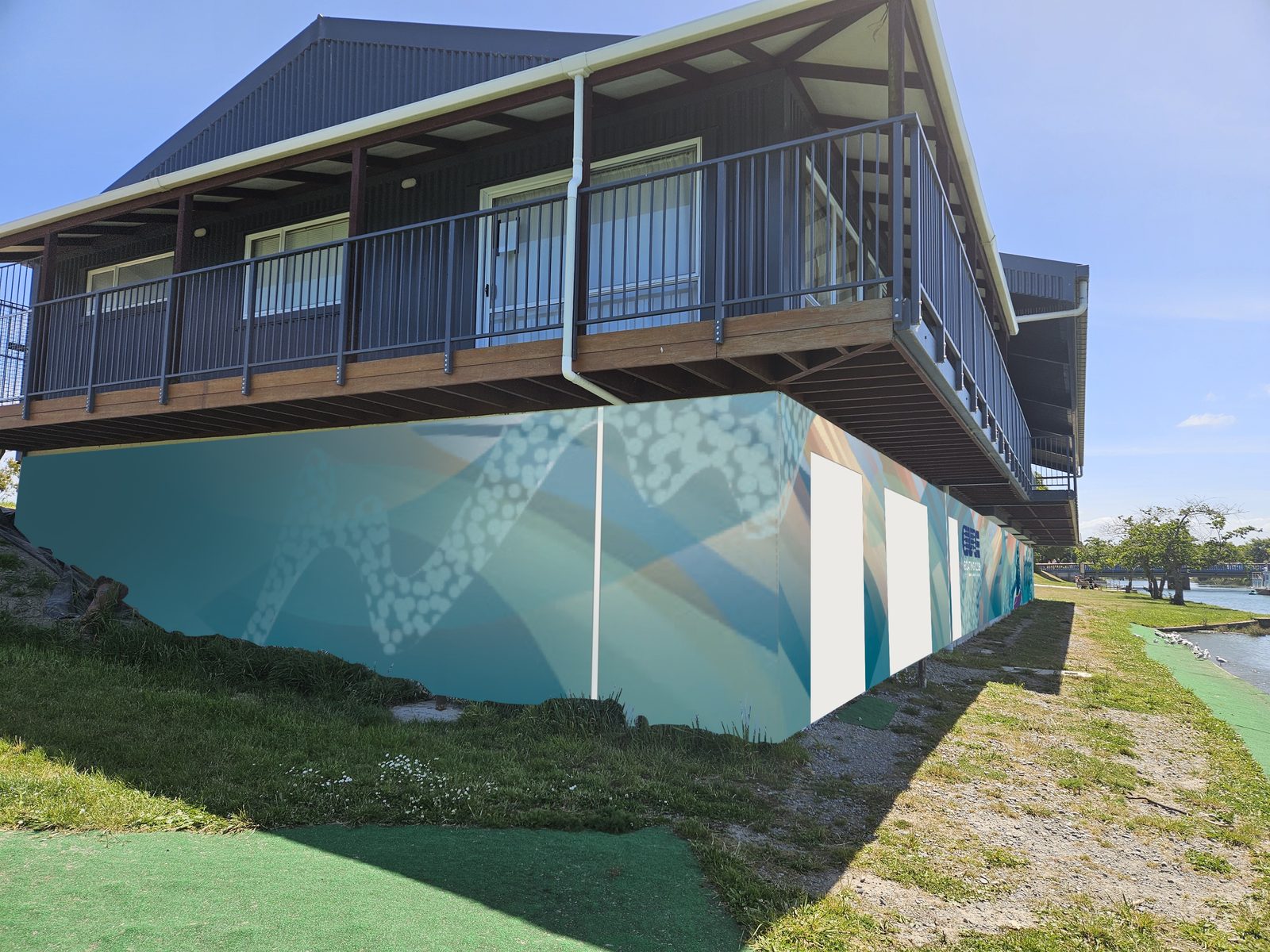 Pulling Together mural — view of the clubrooms balcony and mural from the riverbank