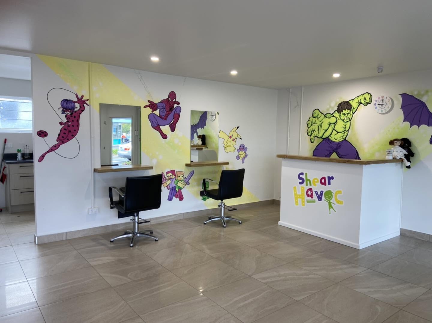 Shear Havoc mural — wide view of the salon reception desk with Spider-Man, Hulk and the dragon character on the walls