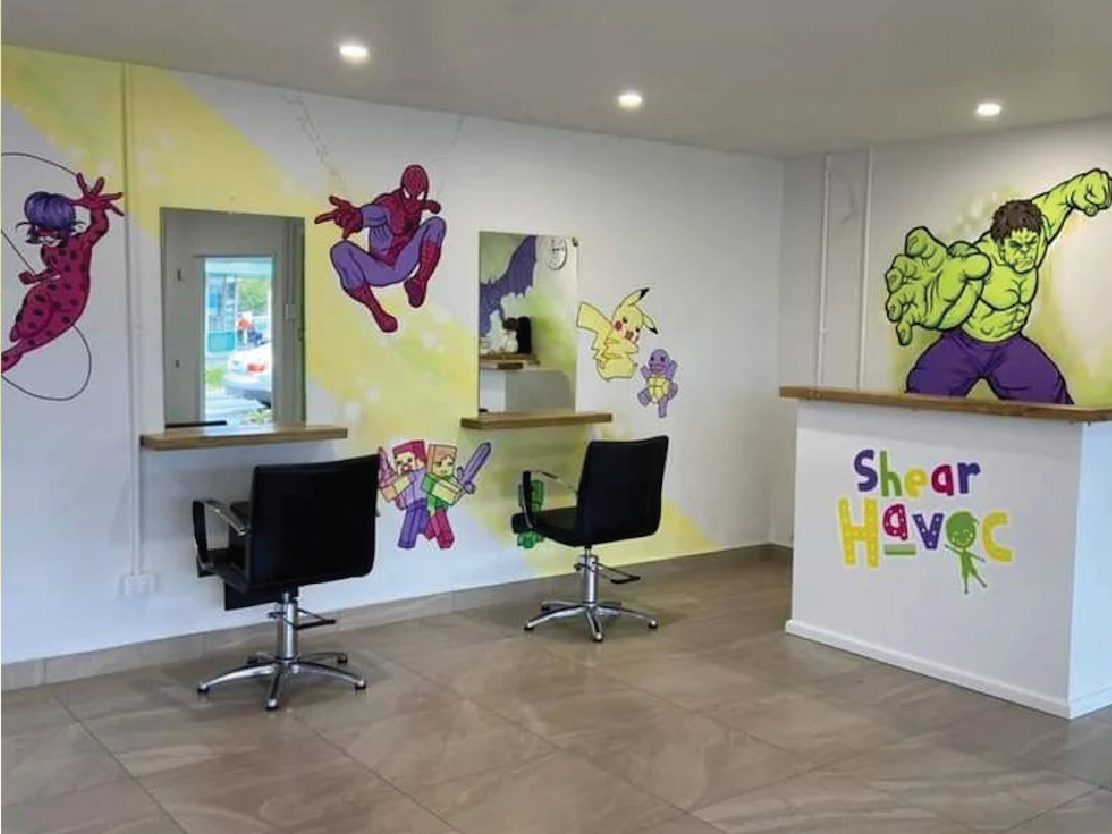 Shear Havoc mural — wide view of the finished salon with characters across the walls and reception desk