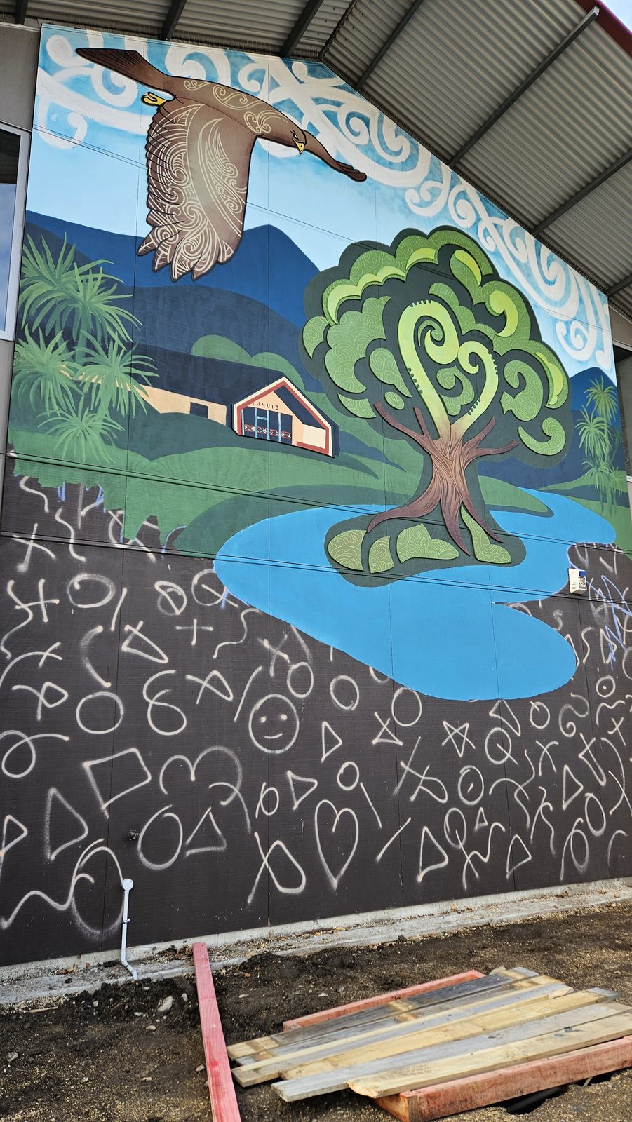 Around The Tree mural — finished hills, lake and tree landscape with a kārearea overhead