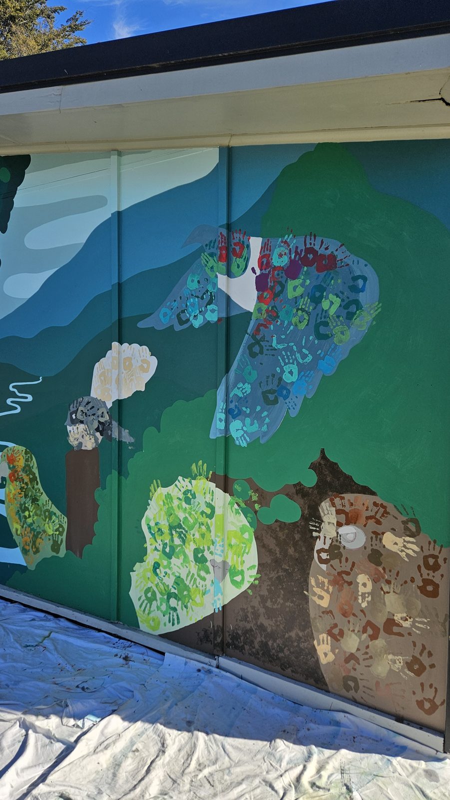 Flock Together mural in progress — native bird shapes blocked in colour on the wall