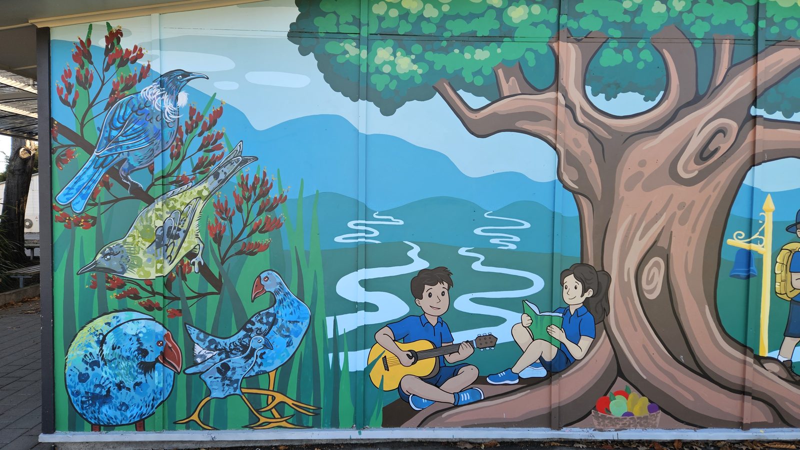Flock Together mural — wide view of the finished tree, students and native birds