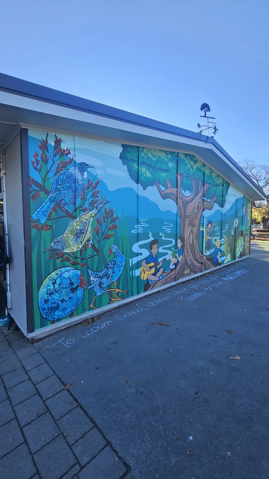 Flock Together — building exterior with the finished mural visible on the far wall