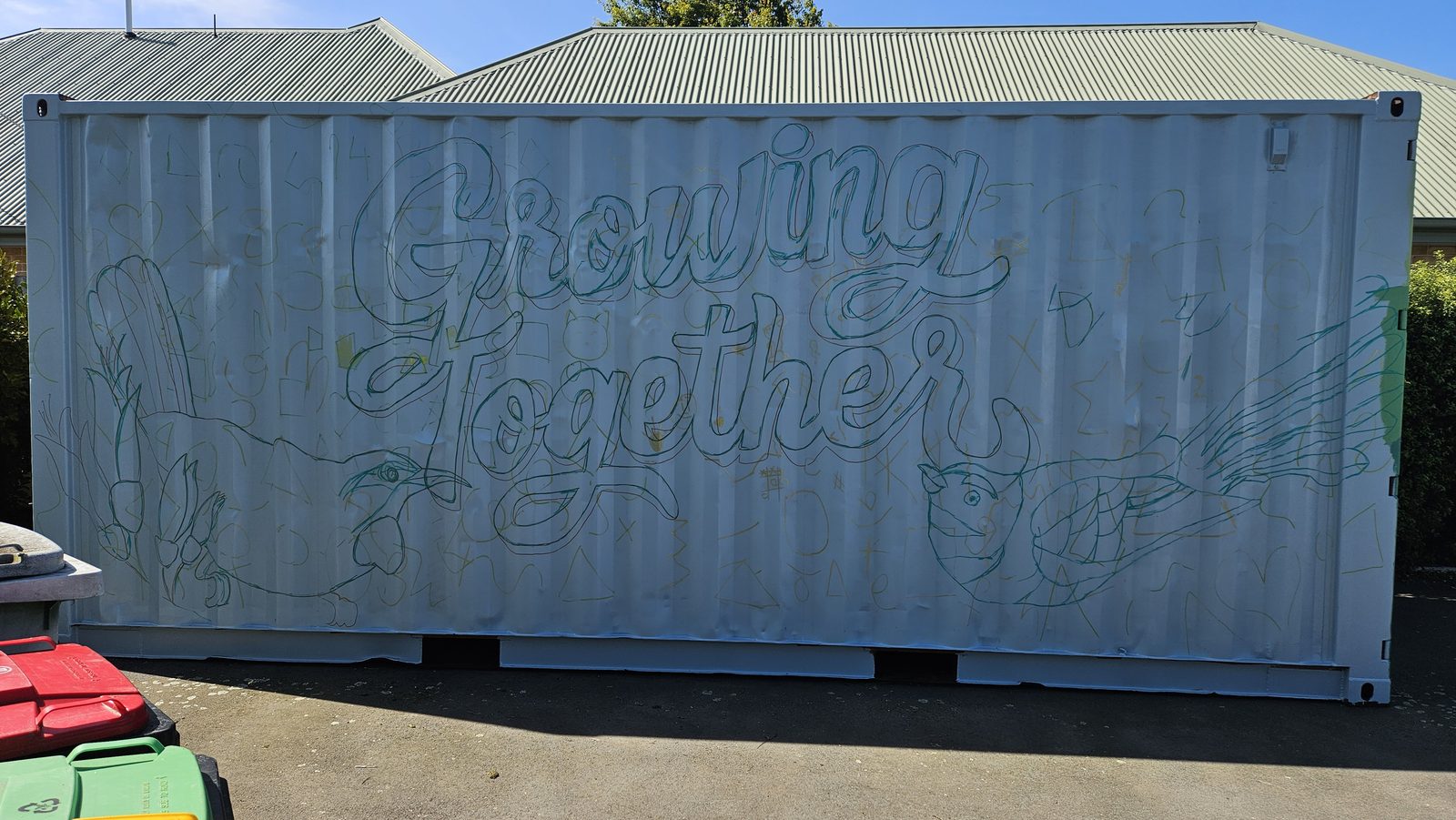 Growing Together mural in progress — sketch outline of the lettering and leaf shapes on bare metal