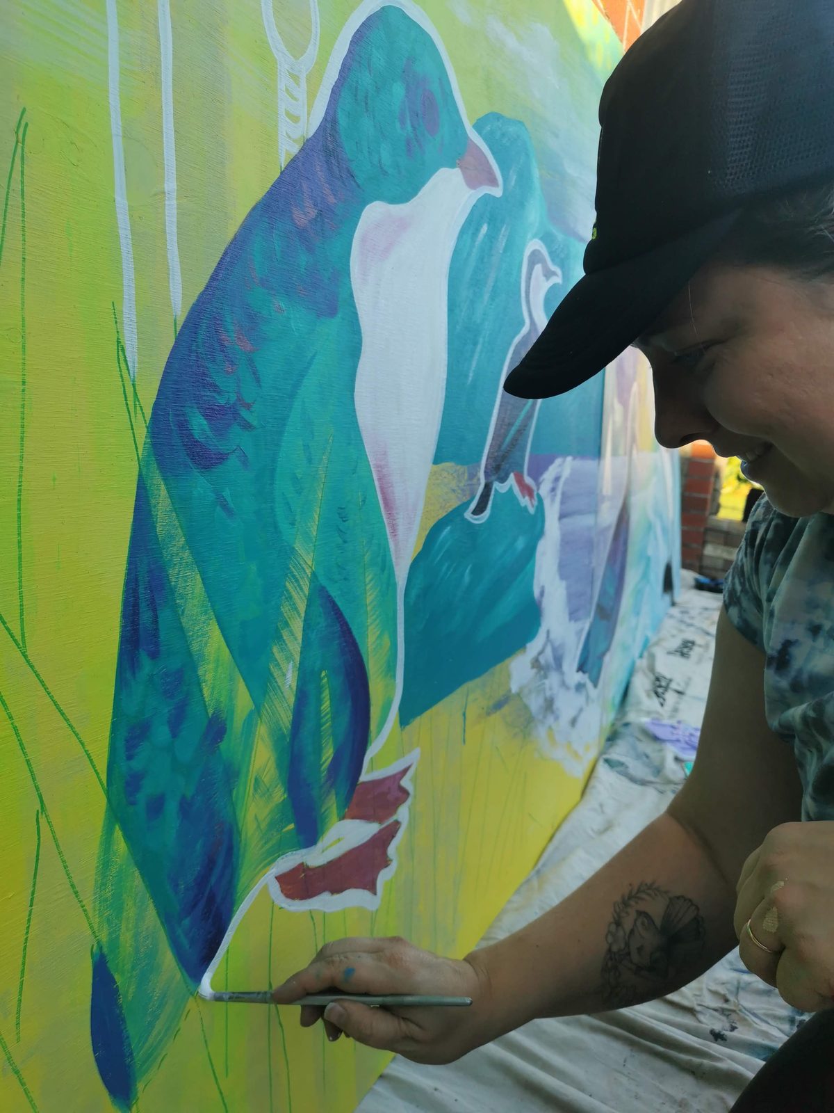 Natures Playground mural in progress — Mel finishing detail on a bird panel