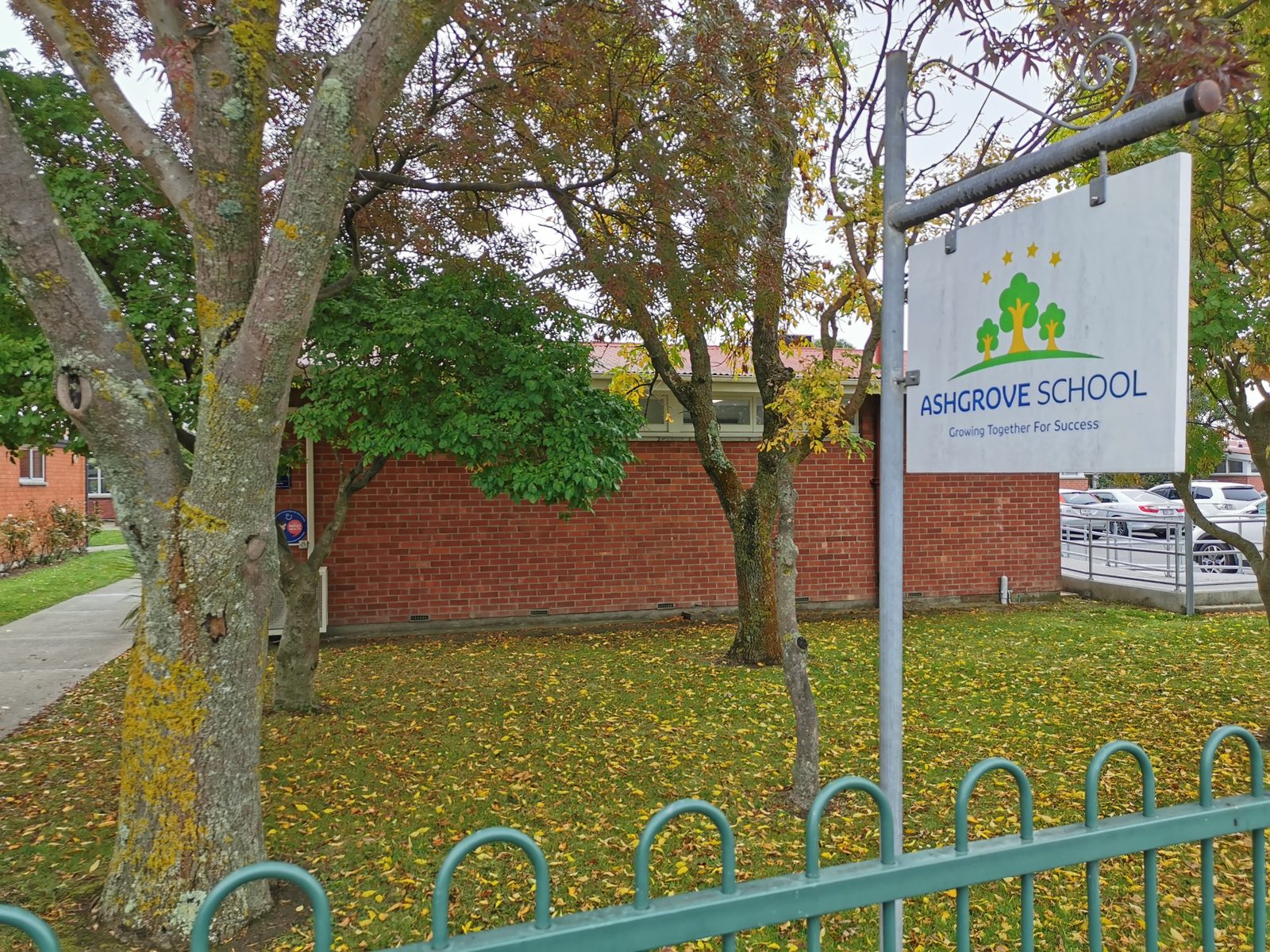 Ashgrove School sign on the grass near the mural site
