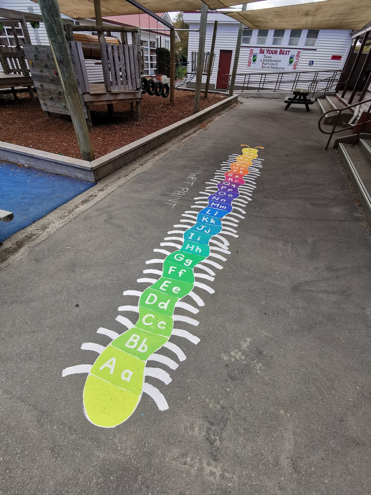 Playtime Bugs — a long colourful caterpillar number game painted across the court
