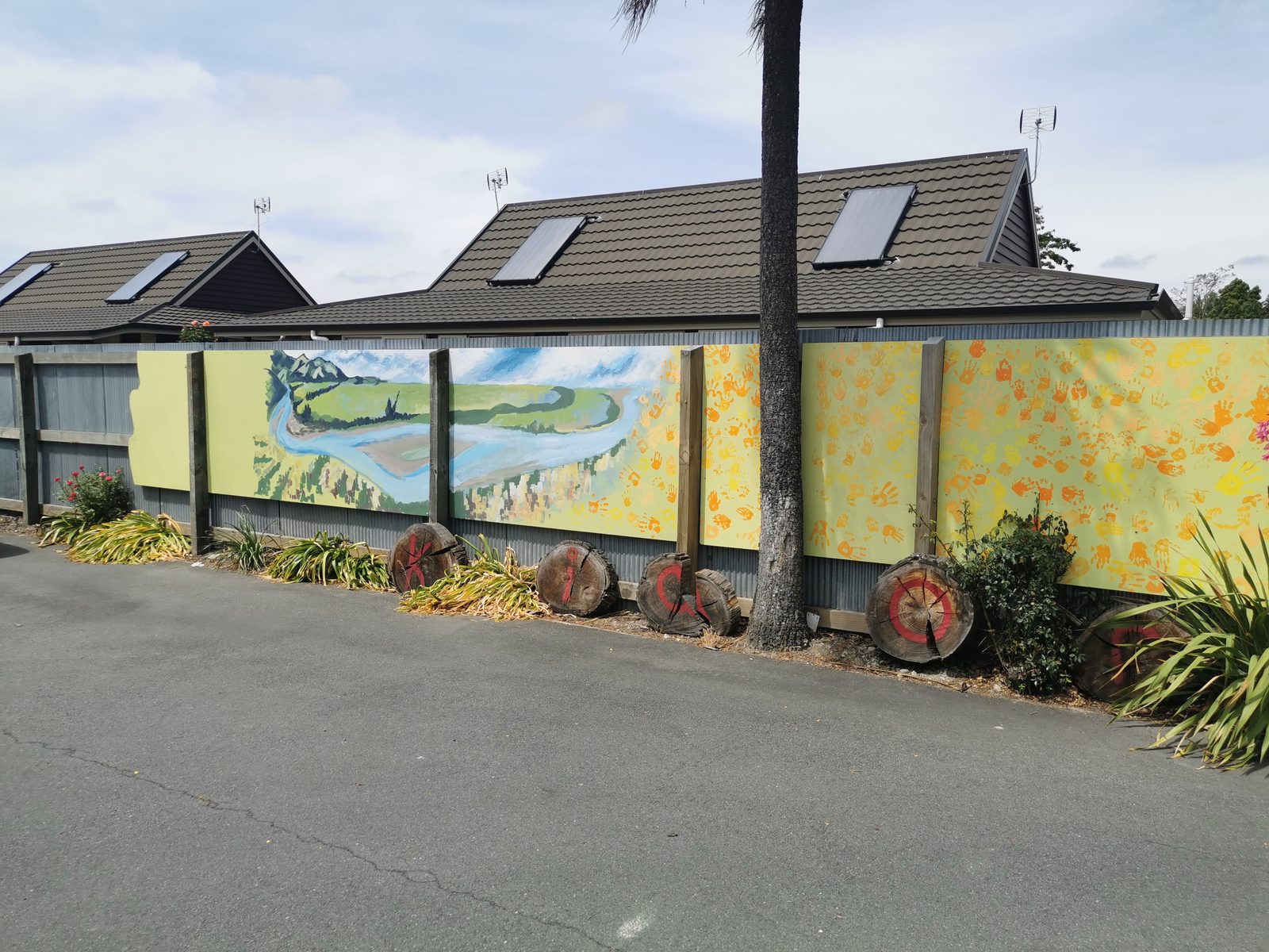 Weaving Together mural — wide view of the fence with finished panels