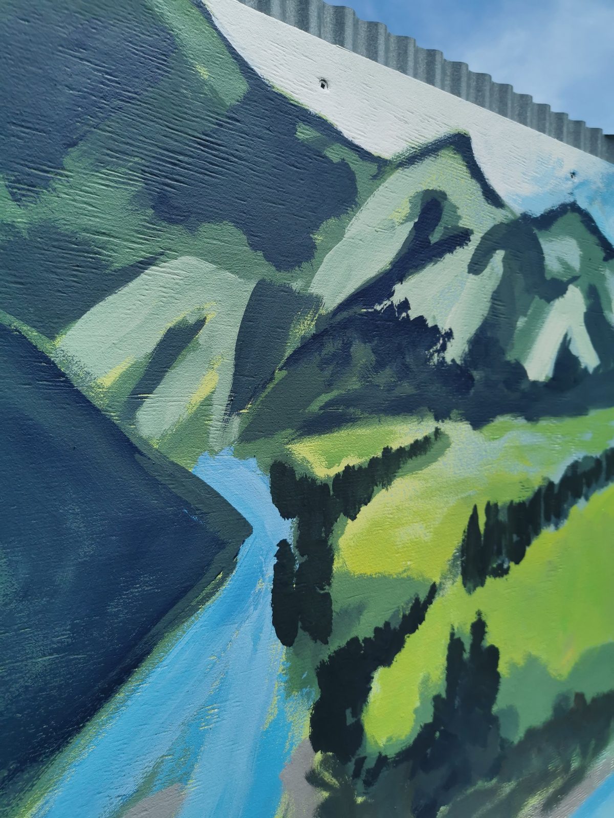 Weaving Together mural detail — a painted river and hills landscape panel