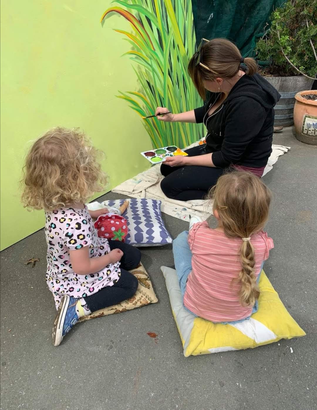 Weaving Together — two preschoolers painting a yellow handprint panel together