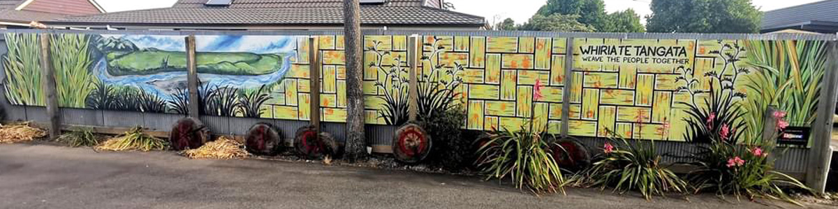 Weaving Together mural — harakeke basketweave pattern and a river landscape panel along the fence, with the whakataukī 'Whiria te tāngata, weave the people together'