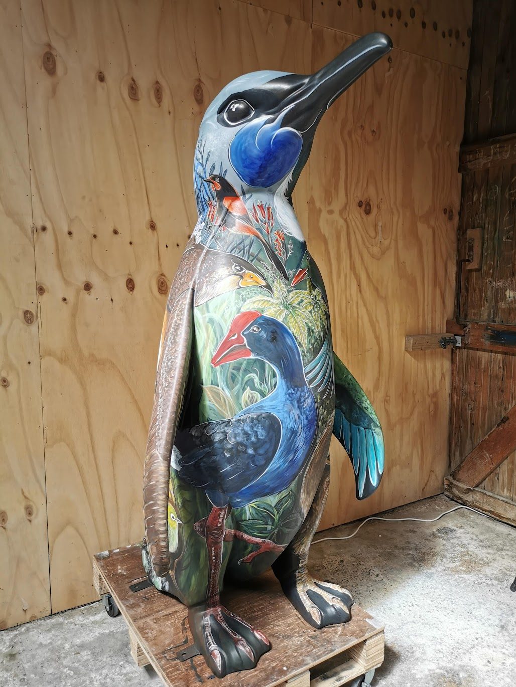 Birds of a Feather — the painted penguin sculpture in the workshop