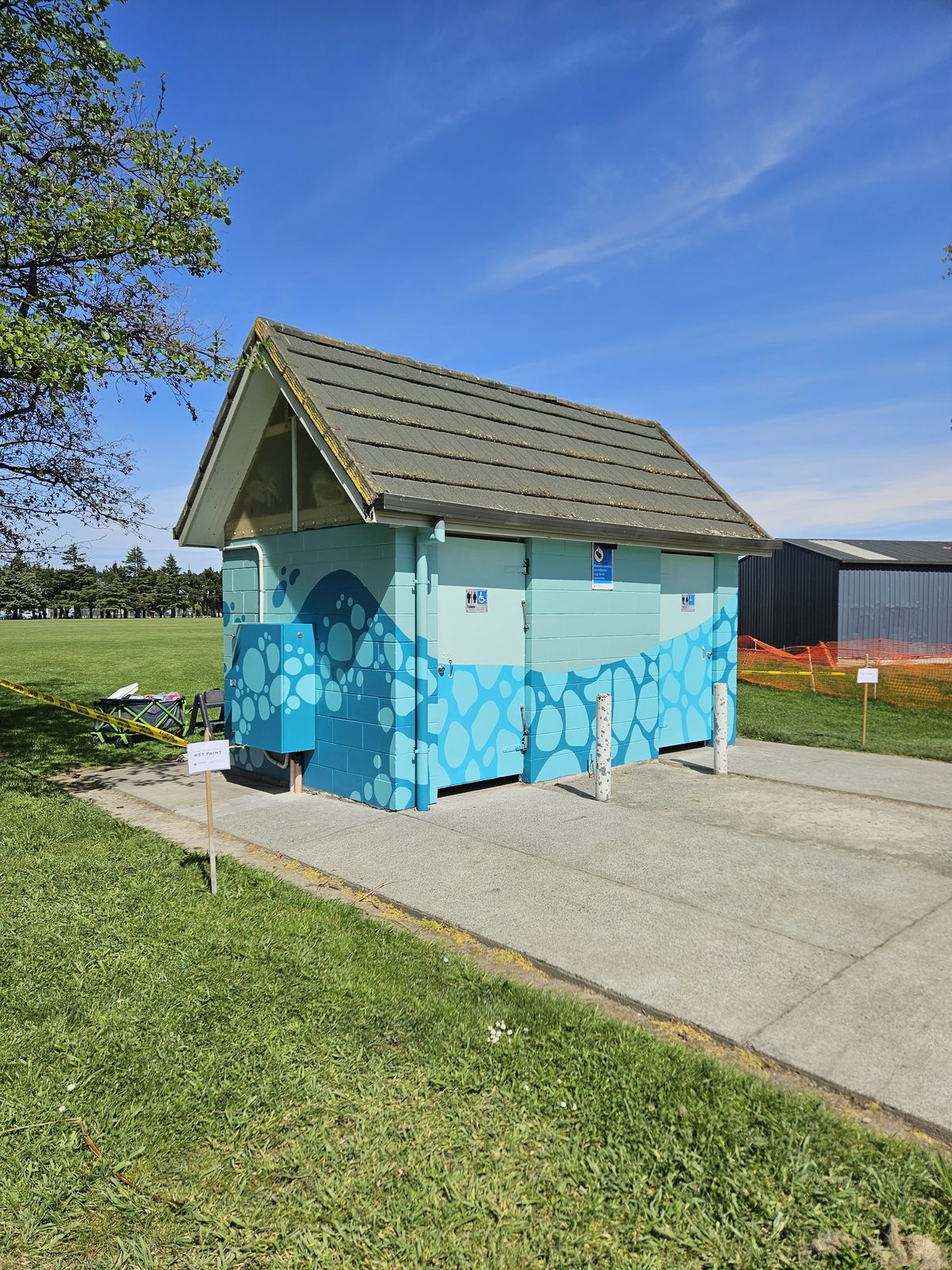 Flowing With Whio mural in progress — blue gradient covering most of the building's side wall