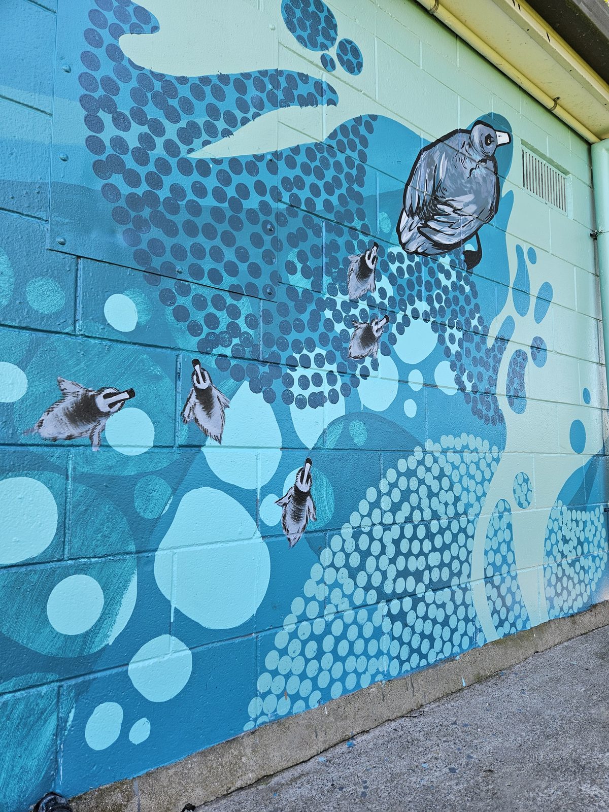 Flowing With Whio mural detail — close-up of the wave pattern on the building corner