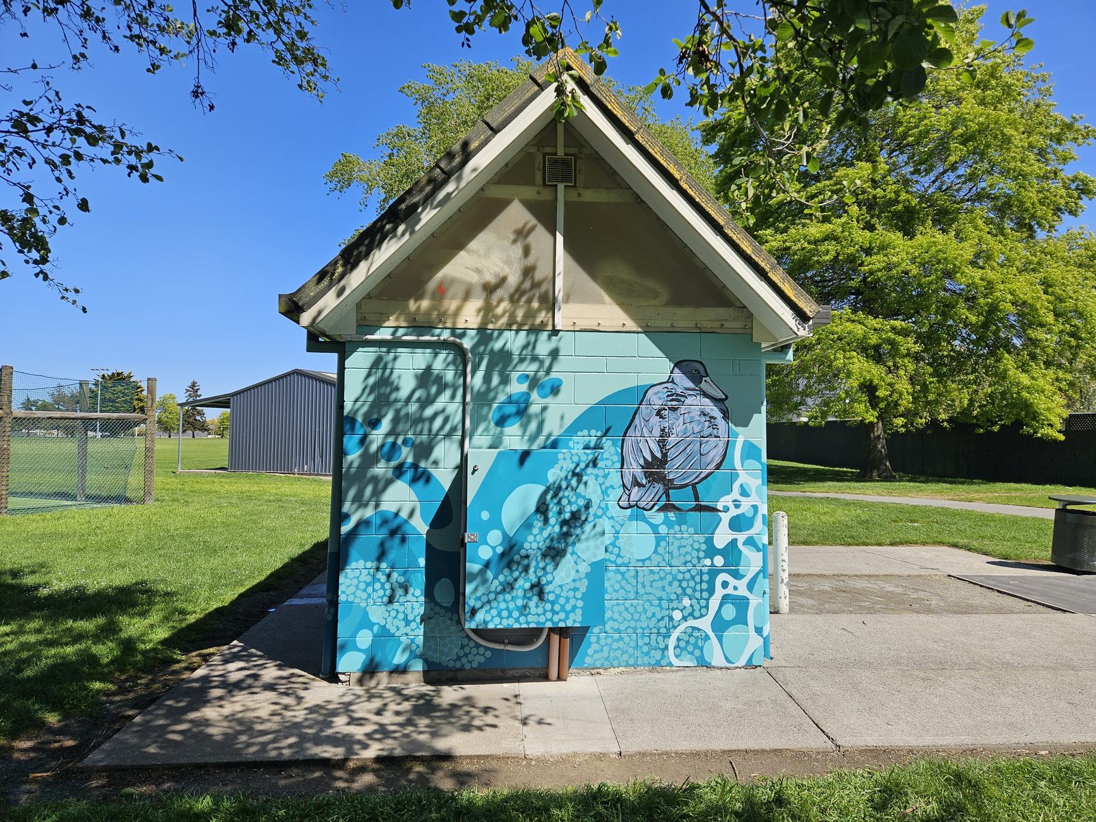 Flowing With Whio mural — finished building viewed from the park
