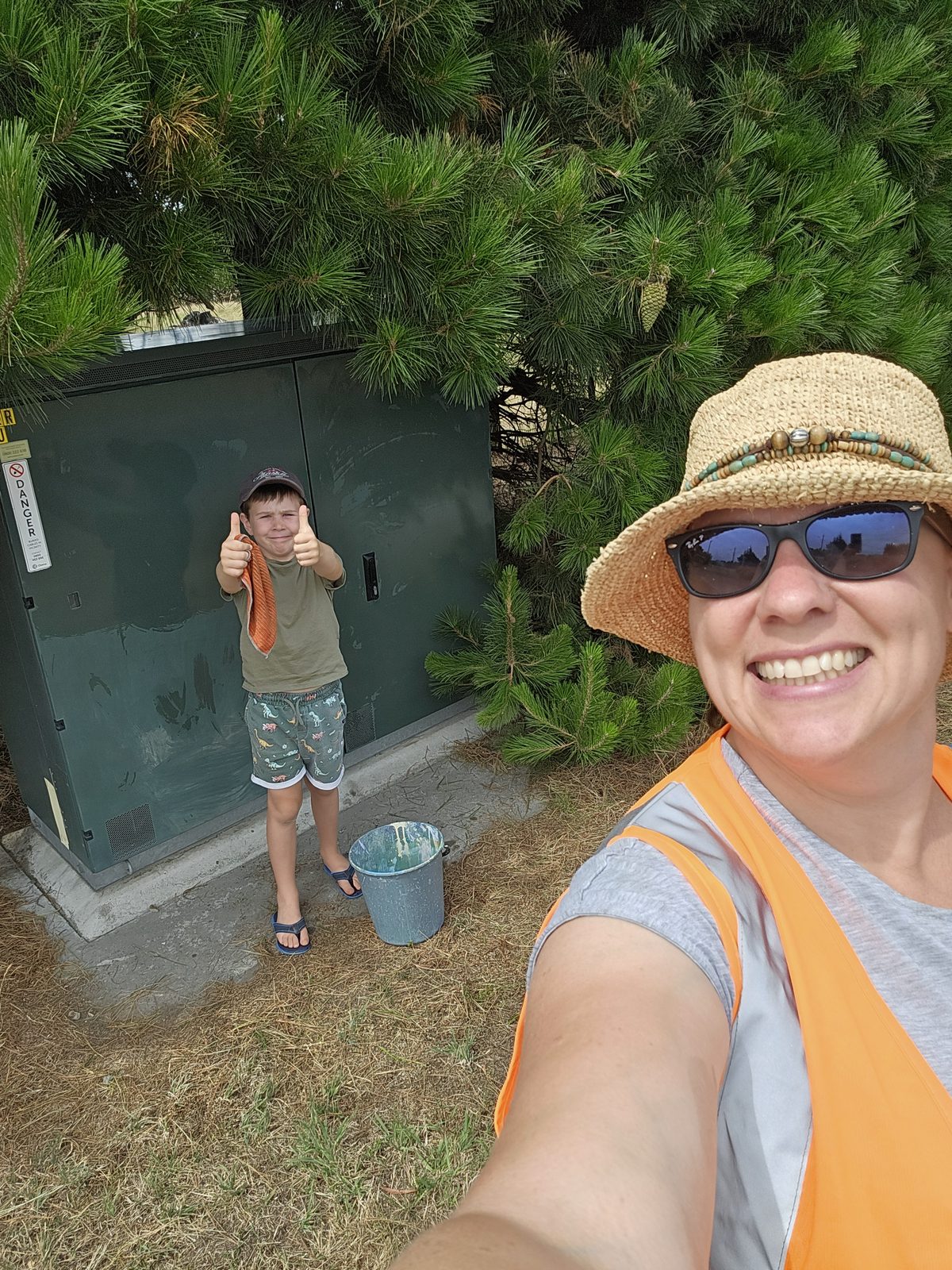 Hidden Treasure — Mel beside the Chorus cabinet tucked into the pine hedge before painting