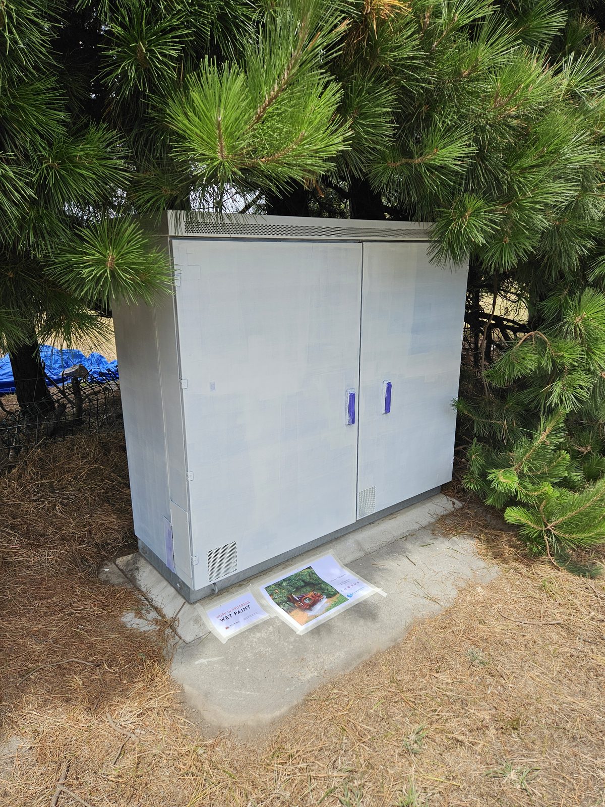 Hidden Treasure — plain grey Chorus cabinet before the mural, tucked into the hedge