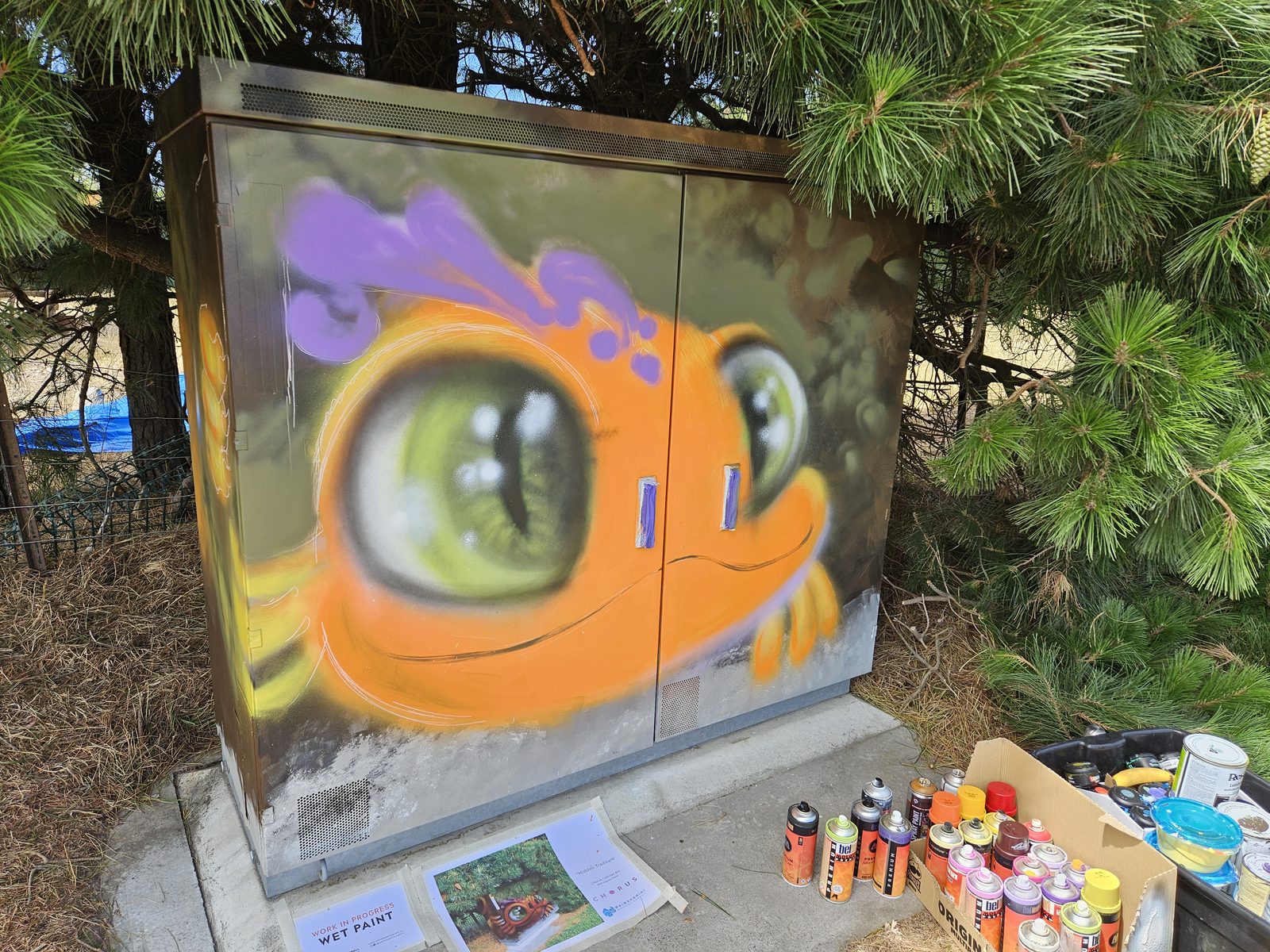 Hidden Treasure mural — finished dragon design with painting supplies laid out in front