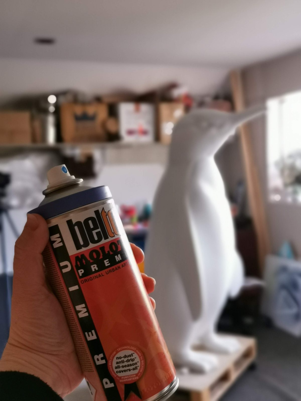 Ice sculpture — blank penguin sculpture with spray paint cans in the workshop