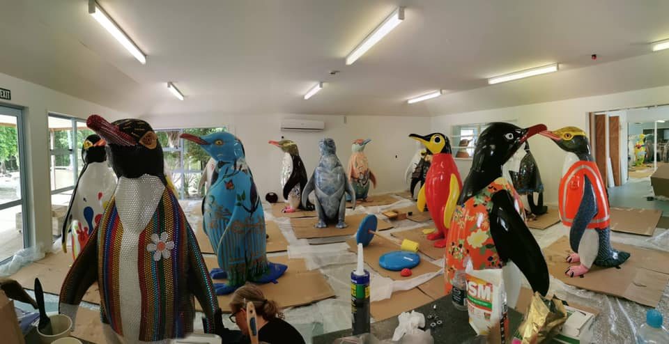 A line-up of differently painted penguin sculptures in the workshop ahead of the Pop-up Penguins trail