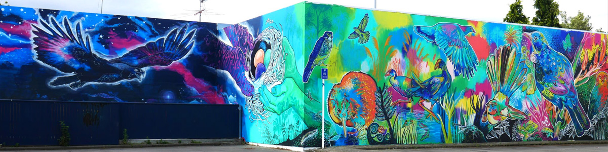 In Our Hands mural — full view of the Haast eagle, the hands of Ranginui and Papatūānuku cradling a nest of eggs, and colourful native birds across the Rangiora carpark wall
