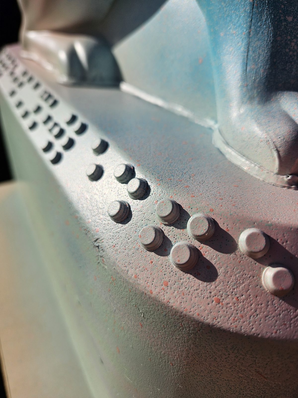 Louis Braille sculpture detail — close-up of the raised braille dots near the ear