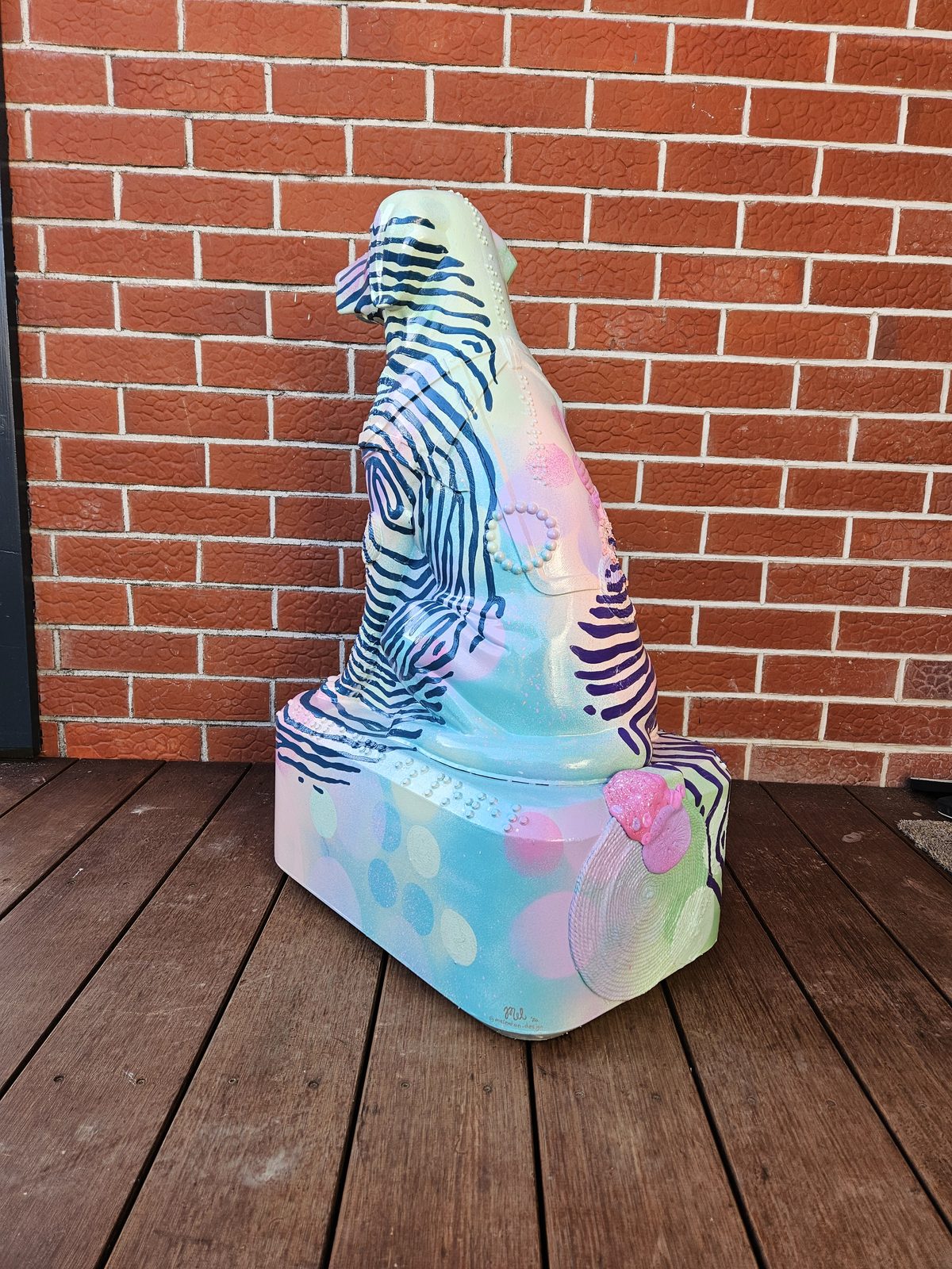 Louis Braille sculpture — finished design viewed from the deck against the brick wall