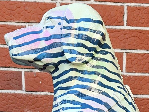Louie Braille sculpture detail — close-up of the striped paintwork on the dog-shaped coin collection sculpture