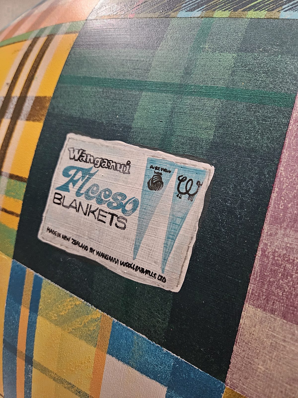 Mammoth Wolley sculpture detail — patchwork pattern with a wool mill label sticker