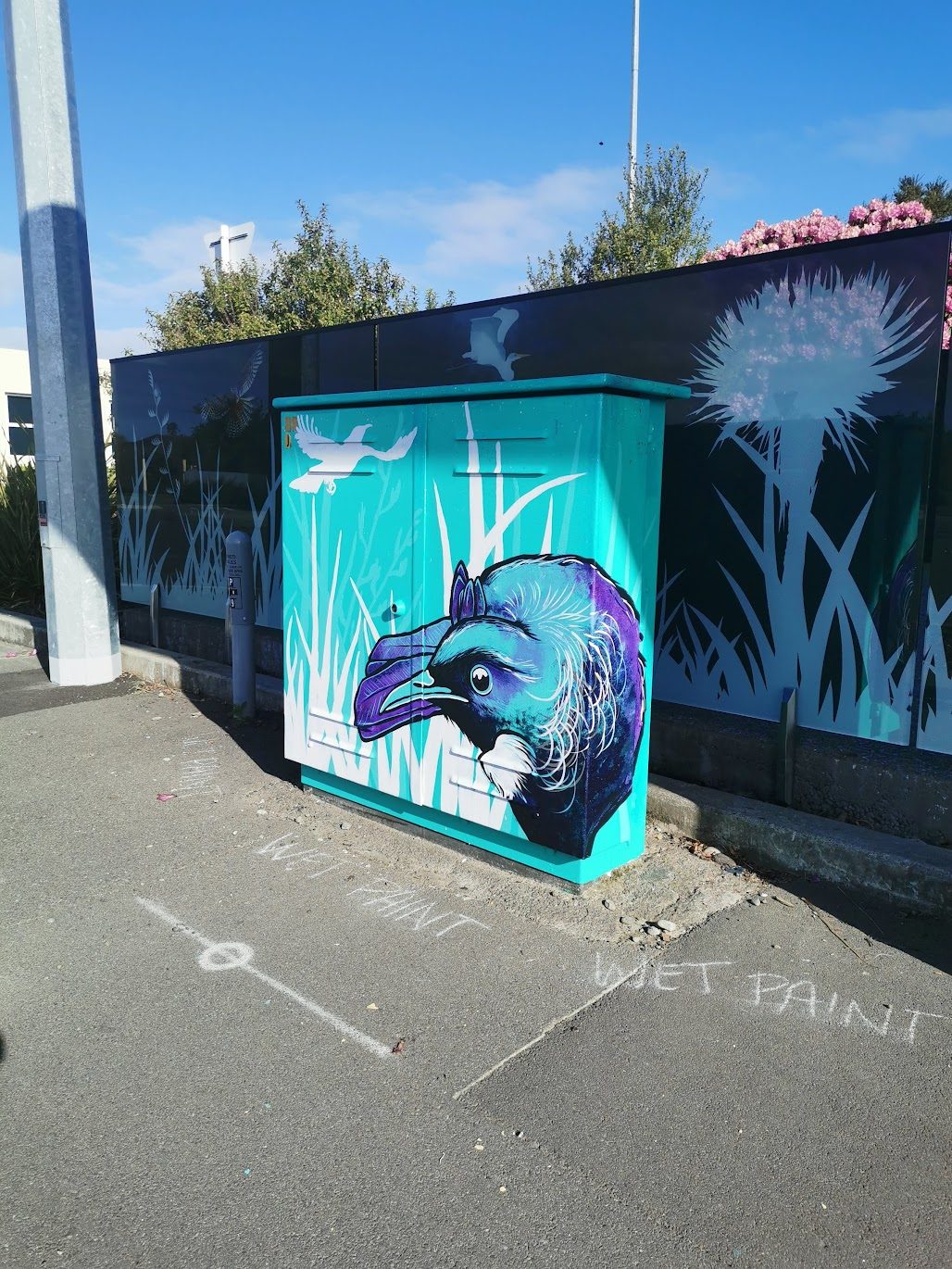 Tui Song mural — wide view of the finished tui design against the decal wall
