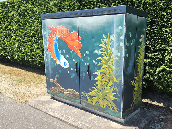 Urban Oasis mural — trompe l'oeil aquarium design with an orange betta fish and seaweed, painted on a Chorus street cabinet