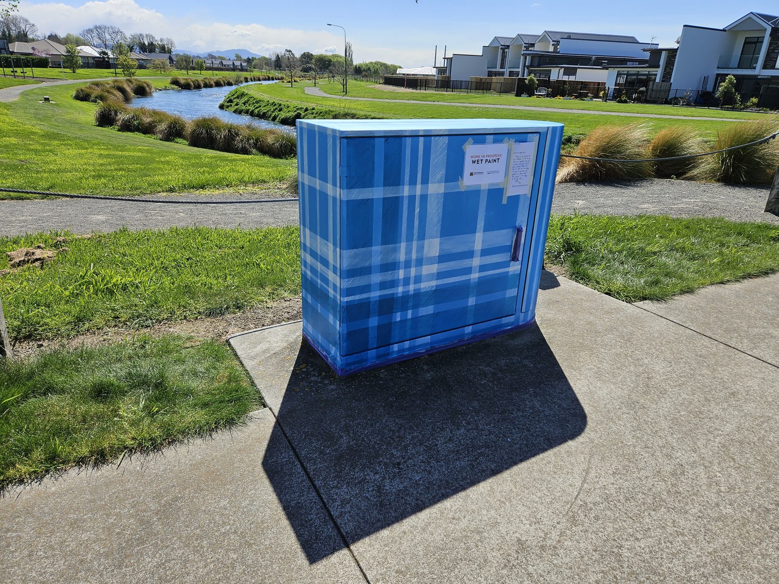 Woven History mural — finished blue plaid cabinet in the residential street